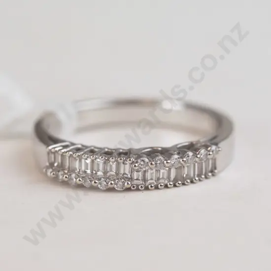 A silver ring with diamond-like material of the top.