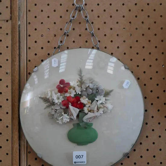 fabric flowers behind convex glass