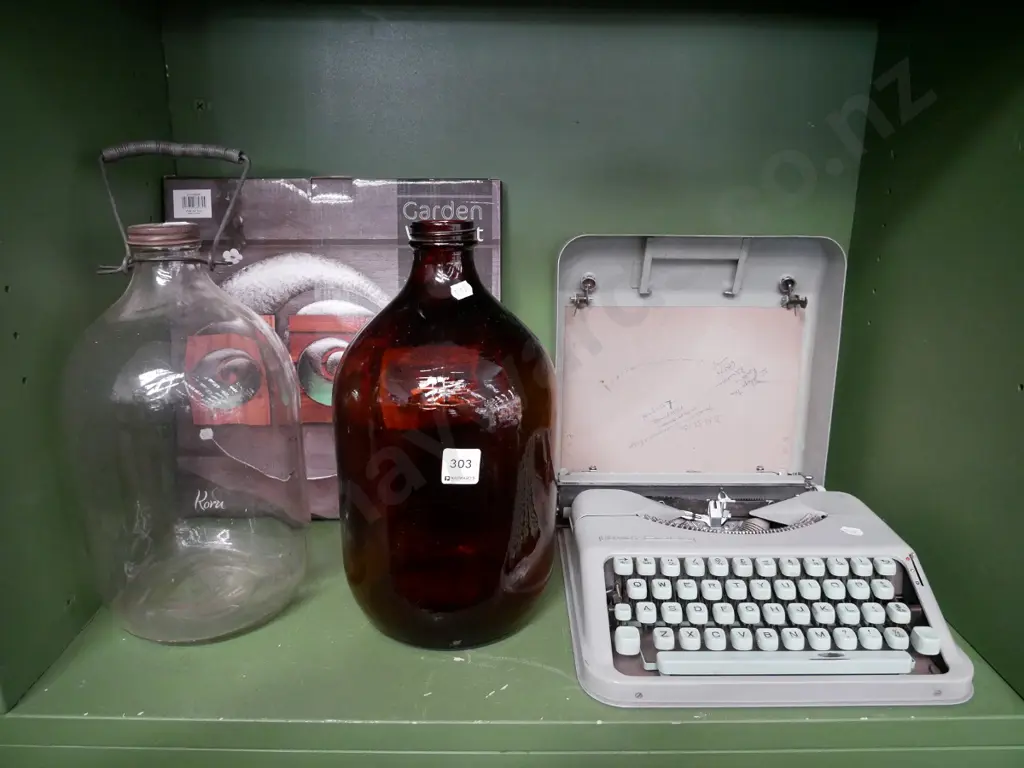 2 glass bottles, wall art, and Hermes portable typewriter Image 1++