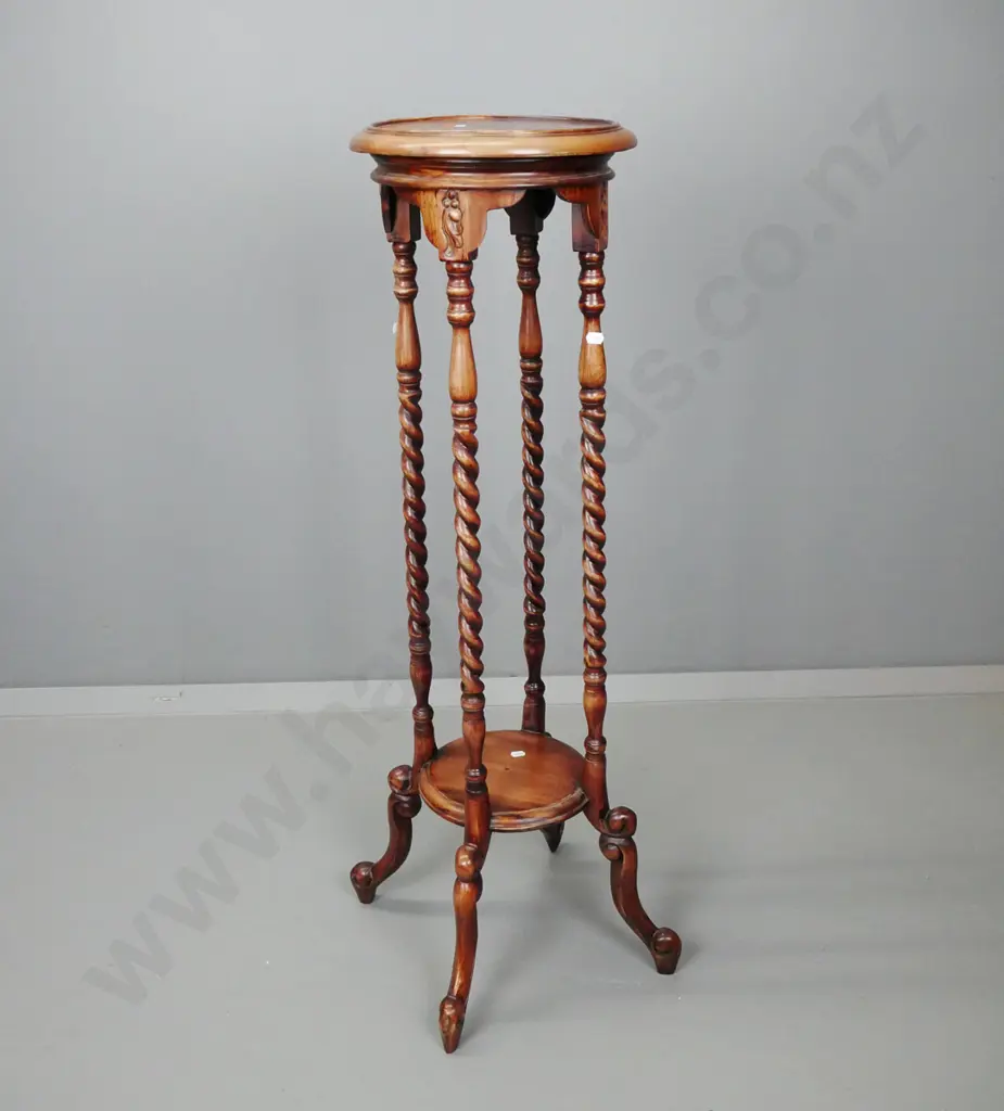 reproduction mahogany plant stand with round top on 4 twisted uprights, lower shelf, 4 scrolling legs, fading to polish. Image 1++
