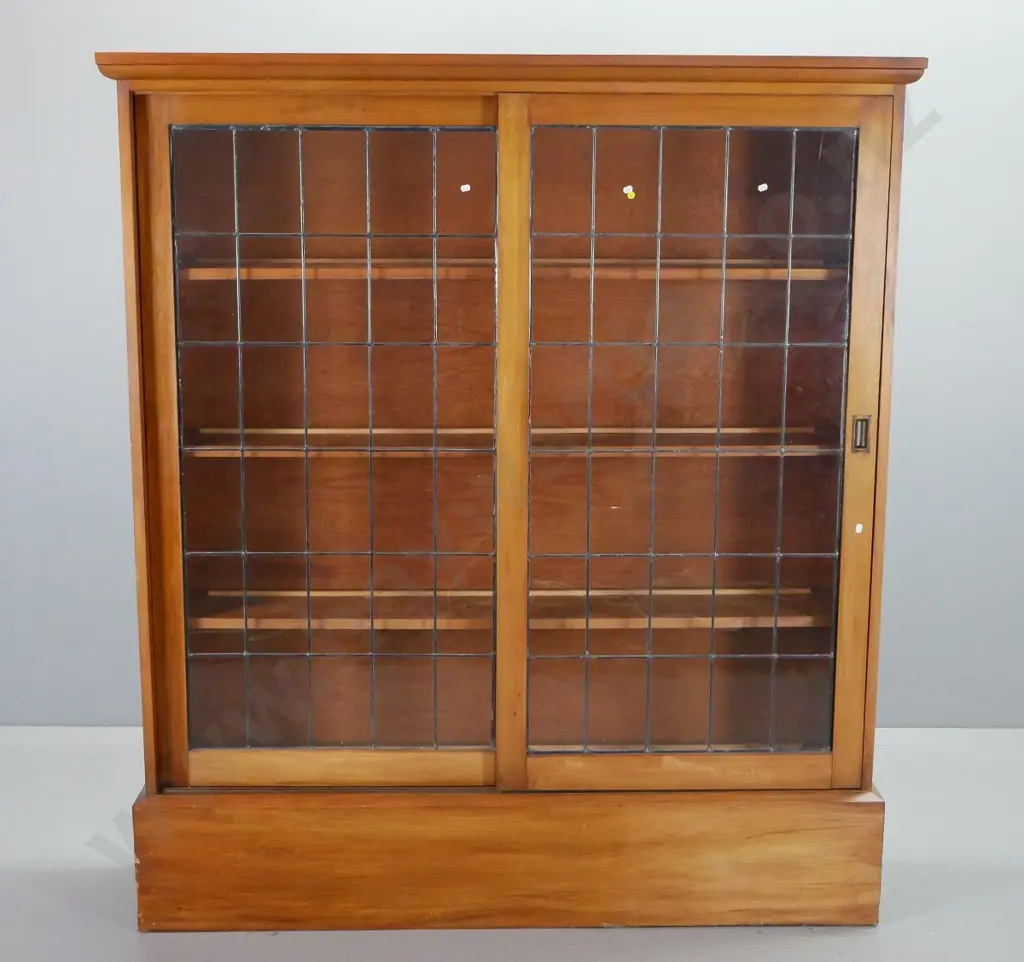 arts & crafts style rimu 3-shelf bookcase with 2 sliding leadlight doors, shaped cornice top and large plinth base. Image 1++