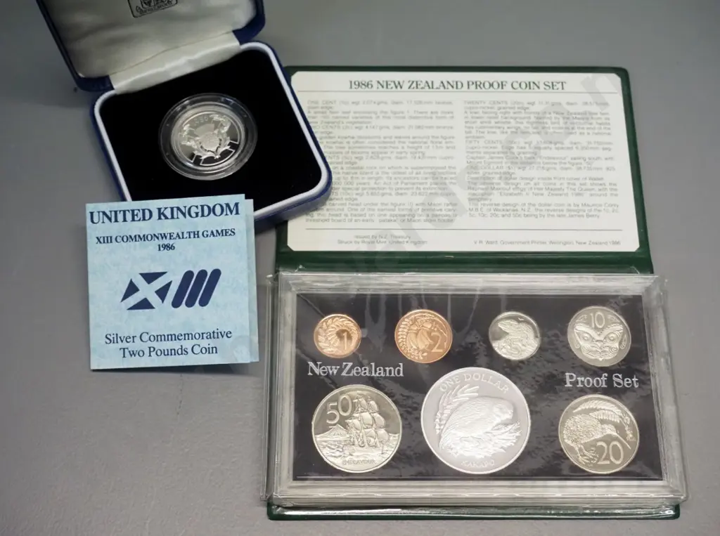 2 cased coins sets - New Zealand 1986 proof set and cased UK 1986 Commonwealth Games 2 pound proof - booklet mentions 2 Image 1++