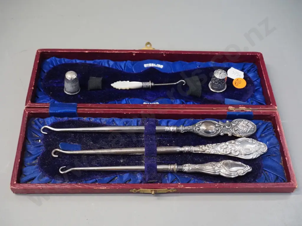 3 sterling silver handled button hooks in fitted case, 2 thimbles, one marked sterling, and a small mother of pearl Image 1++