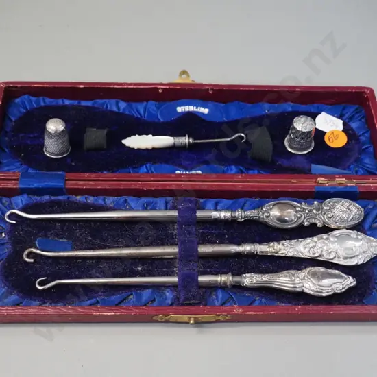 3 sterling silver handled button hooks in fitted case, 2 thimbles, one marked sterling, and a small mother of pearl