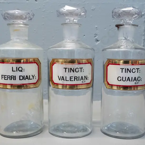 3 clear glass stoppered apothecary bottles with labels H-240 D-90