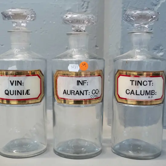 3 clear glass stoppered apothecary bottles with labels H-240 D-90