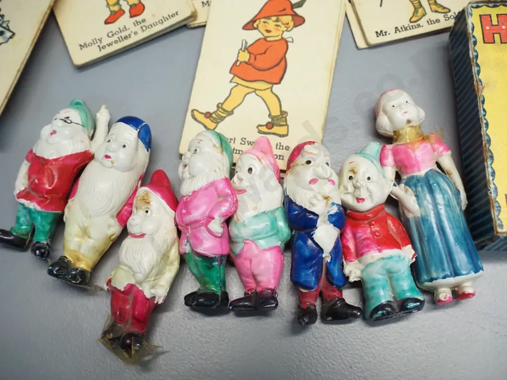 set of thin celluloid Snow White and 7 dwarves figures and a vintage Happy Families card game. Snow White has had repair Image 1++