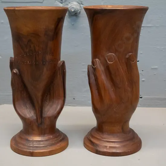 pair of hand carved timber cups or vases with relief hands, each marked 'Souvenir of Pitcairn Island' H-205