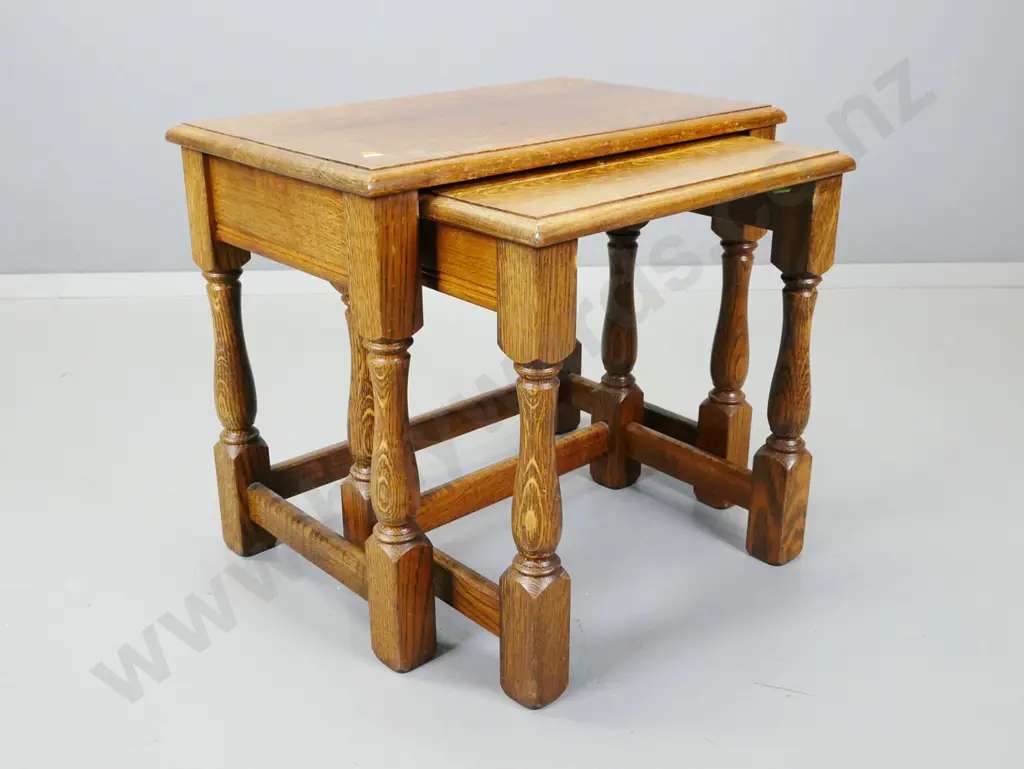 2 vintage oak nesting tables on turned bolster legs - wear to polish on both tops. Larger H-480 W-560 D-350 Image 1++