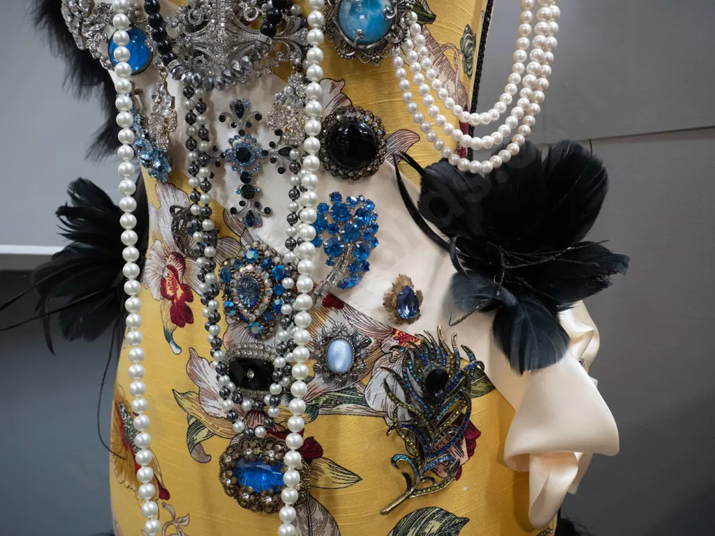 fabric covered timber-based dressmaker's form / mannequin decorated with braid, feathers, and numerous pieces of costume Image 1++