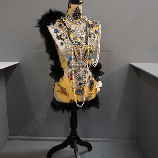 fabric covered timber-based dressmaker's form / mannequin decorated with braid, feathers, and numerous pieces of costume