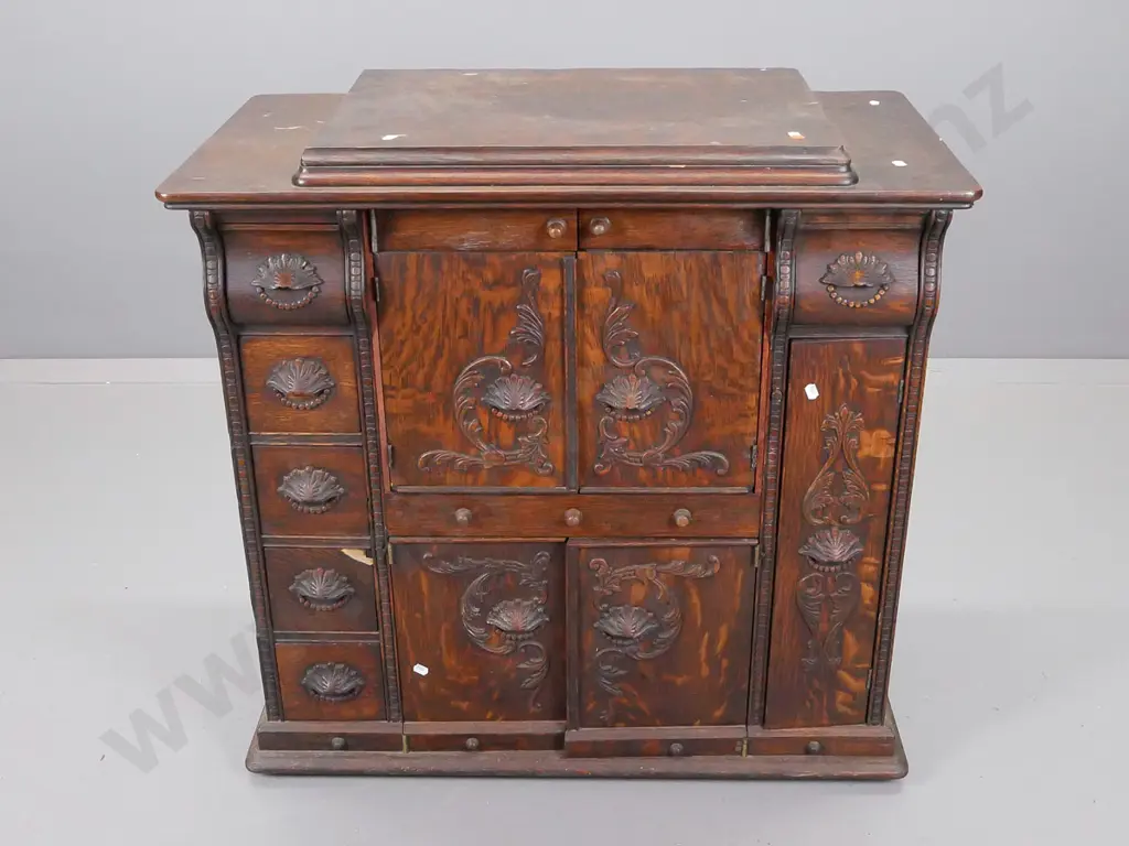 oak cupboard with lift up lid above two sets of central cupboard doors, flanked by five small drawers on one side Image 1++