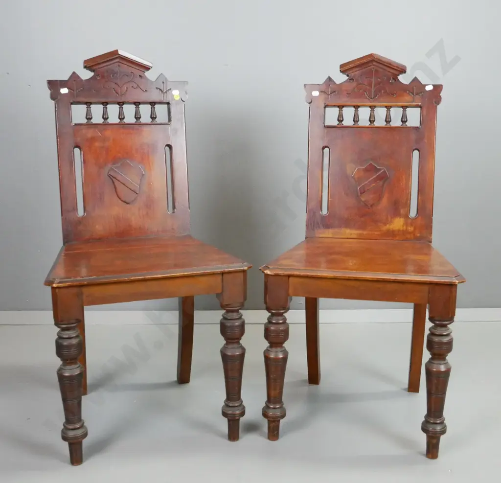 pair of Colonial rimu hall chairs, with turned front legs, spindle gallery, shield armorial, etc. Join split in seat Image 1++