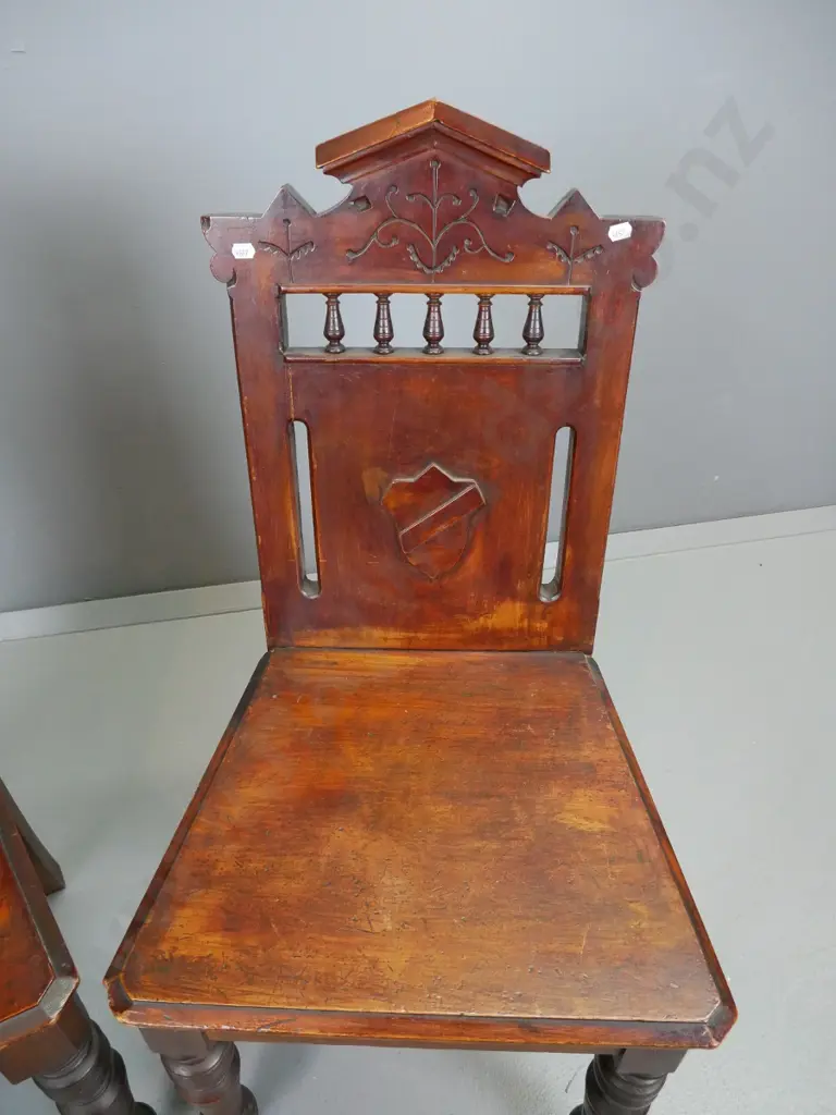 pair of Colonial rimu hall chairs, with turned front legs, spindle gallery, shield armorial, etc. Join split in seat Image 1++