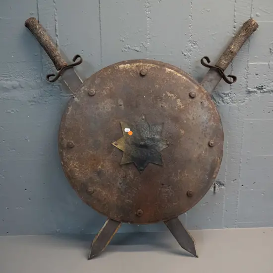 decorative shield and crossed swords - iron with beaten brass star, timber tree branch handles H-800 W-760