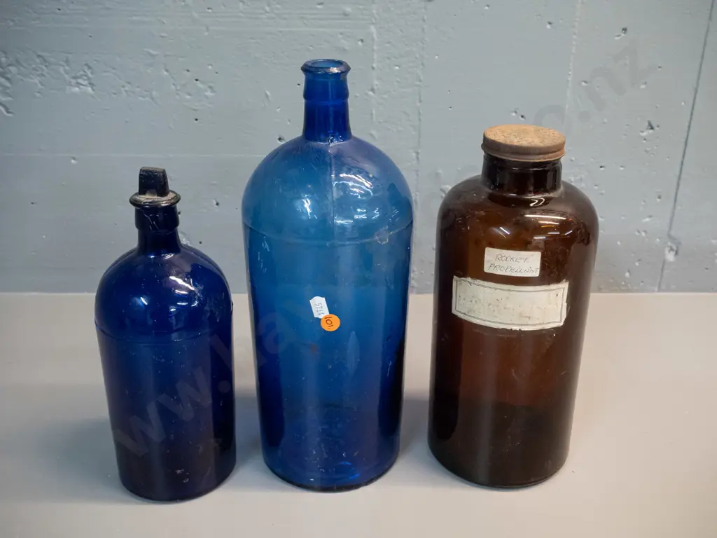 3 vintage bottles - smaller blue one has stuck stopper, brown one with "Rocket Fuel" label. Tallest H340 Image 1++