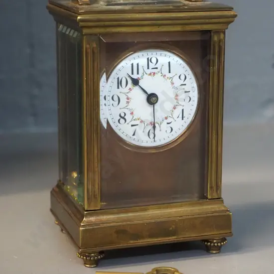 small heavy brass and glass carriage clock with key - no maker's mark, lion emblem on back. H-125 W-75 D65