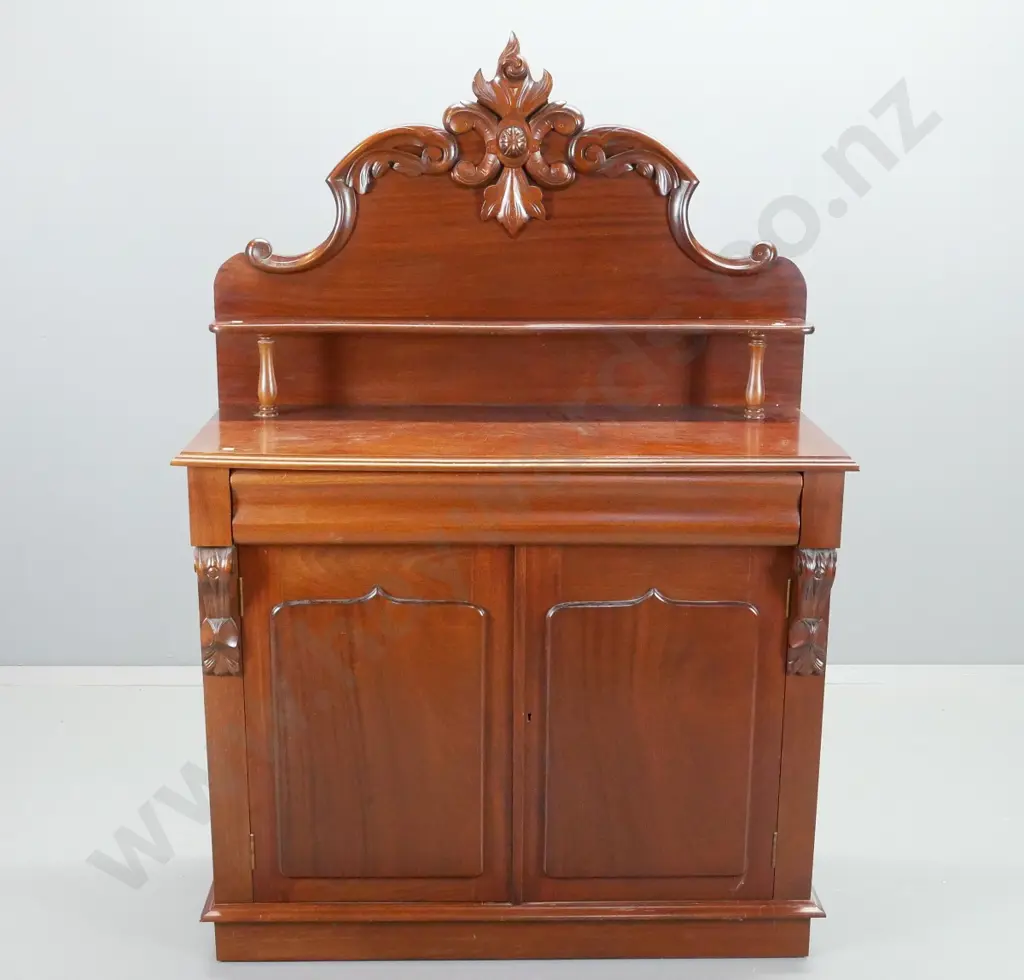 reproduction mahogany carved-back shield-door chiffonier, with key. Large shaped drawer, 2 cupboard doors, shelf to back Image 1++