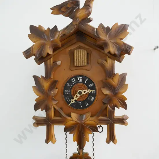 wood-cased cuckoo clock with 2 weights, lift-off top trim piece. Some numbering worn off. Case H-280 W-200
