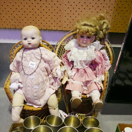 2x porcelain dolls in chairs
