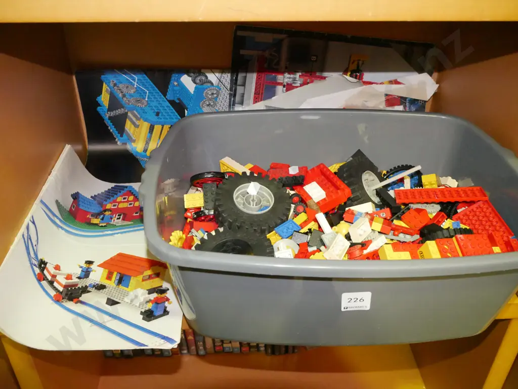 plastic tub of early Lego pieces and instruction books Image 1++