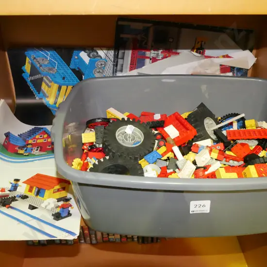 plastic tub of early Lego pieces and instruction books