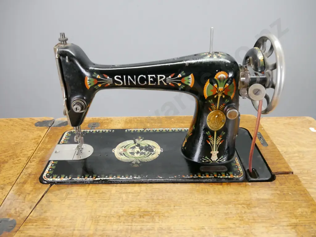 Singer treadle sewing machine with cast iron base, oak cabinet, press carved decoration, vintage fan marked Singer in Image 1++