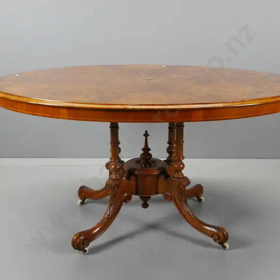 Victorian walnut tilt-top oval loo table with inlaid stringing and foliate decoration on top, 4-point cathedral base,