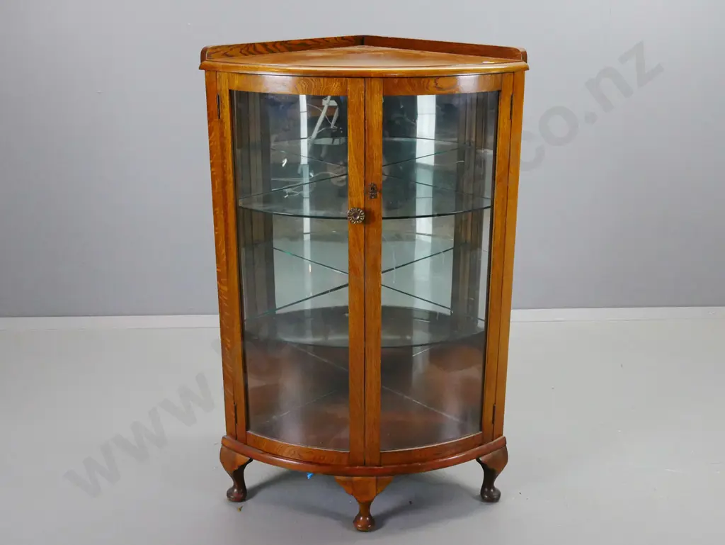 vintage oak corner display case with 2 bowed glazed doors, 2 glass shelves, 3 short cab legs. Working lock & key. Image 1++