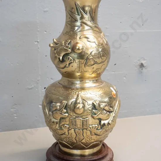 heavy brass vase with deep figural Chinese style relief dragon motifs, marked Made in India, with timber stand. Damage
