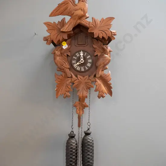 wood-cased cuckoo clock with cast metal weights and plastic face marked Germany - some minor chips to finish (not going)