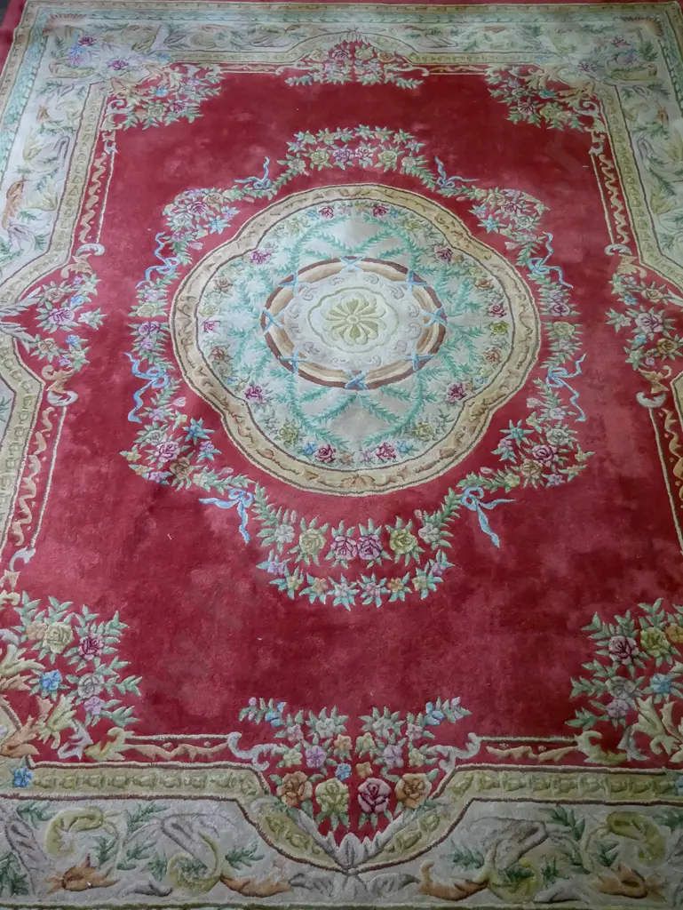 large woollen Asian floor rug, red ground, scalloped central medallion with foliate border Image 1++