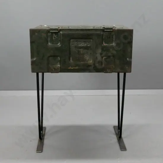 side table made from metal ammunition case on black painted metal base. General age wear and pitting to paint, wobbly