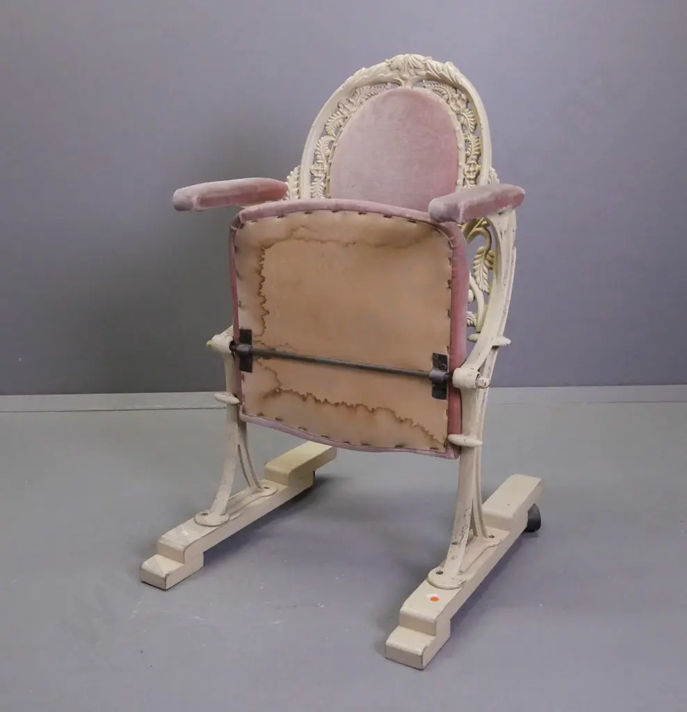cast metal flip-up theatre seat on wooden base with casters on the back, salmon pink upholstery, ex St James Image 1++
