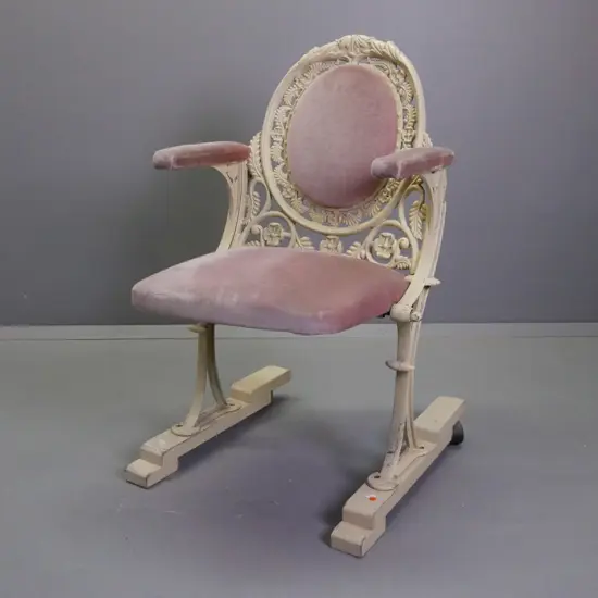cast metal flip-up theatre seat on wooden base with casters on the back, salmon pink upholstery, ex St James