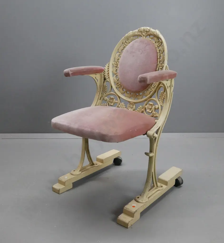 cast metal flip-up theatre seat on wooden base with casters on the back, salmon pink upholstery, ex St James Image 1++