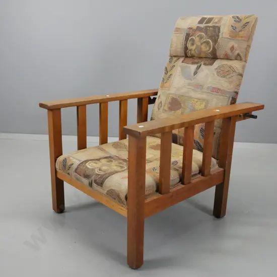vintage beech Morris chair with slat sides, brass adjustment rod, upholstered in earth tone pattern, sagging slightly in