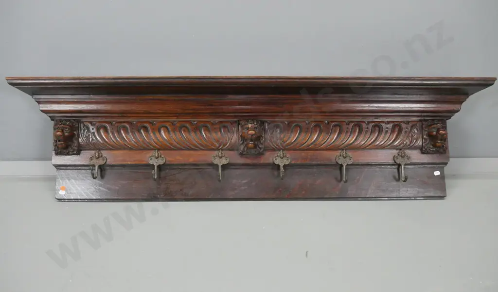 vintage oak wall mount coat rack with platform top, lion's head decoration, 6 brass hooks with figural embossed heads Image 1++