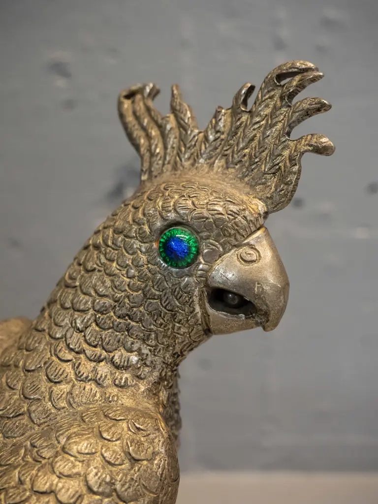 brass finish metal figure of a cockatoo with blue-green glass eyes perched on branch H-270 Image 1++