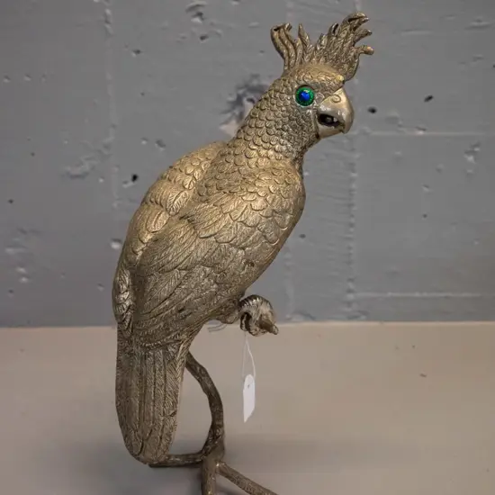 brass finish metal figure of a cockatoo with blue-green glass eyes perched on branch H-270