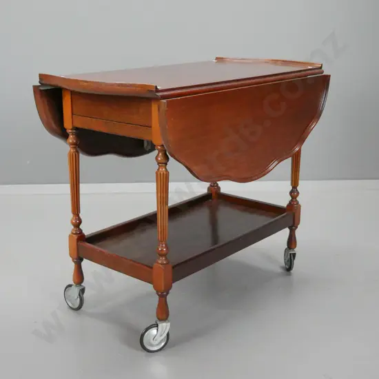 vintage mahogany drop-side tea trolley with shaped moulded top, drawer on one end, pull out baize covered slide on other