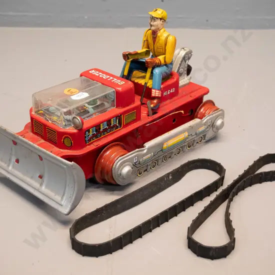 restorer's vintage battery powered tin toy bulldozer with articulated driver, plastic engine cover - rubber tracks have