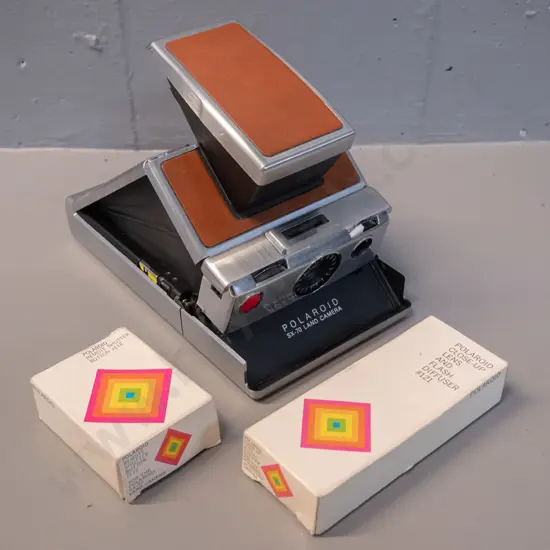 Polaroid SX-70 folding instant camera with boxed cable release and flash attachments - camera opening mechanism a little