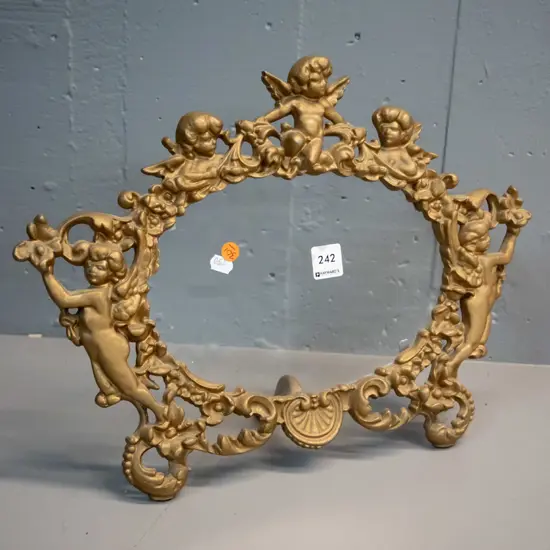 cast metal gilt finish picture frame with ornate putti decoration, glass but no backing H-320 W-425