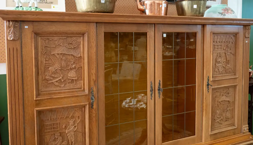 large northern European oak 4-drawer display cupboard 2 leadlight centre doors, 4 carved door panels w/village scenes, Image 1++