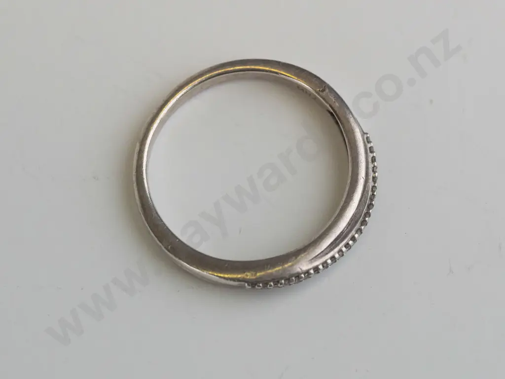 silver ring  set in a crossover ribbon set over white stones Image 1++