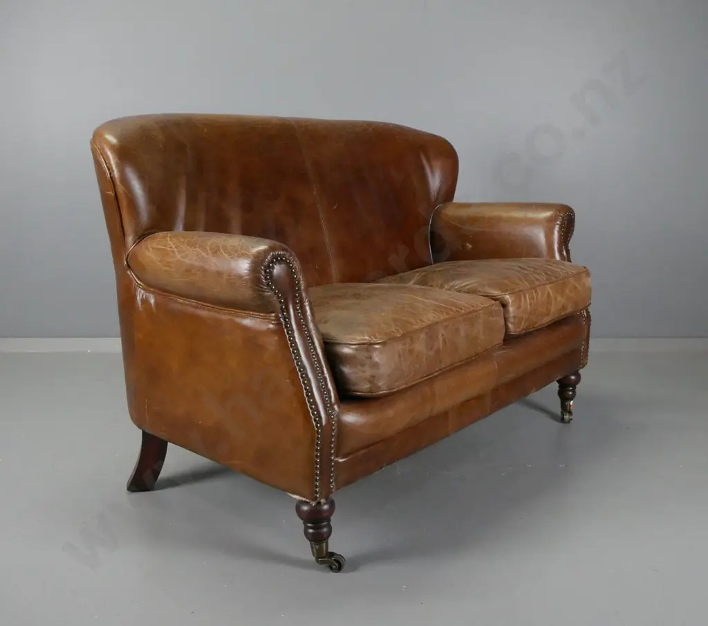 vintage rolled arm brown leather brass studded 2-seater settee on turned legs with brass cup casters - overall age wear Image 1++