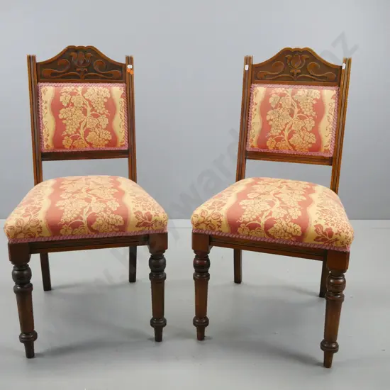 pair of walnut art nouveau style side chairs with shaped, carved crested backs, turned front legs, seat and back covered