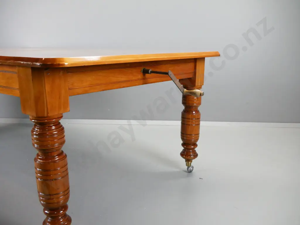 Victorian rimu wind-out extending dining table on heavy turned legs with brass caps and replacement Shepherd's casters - Image 1++