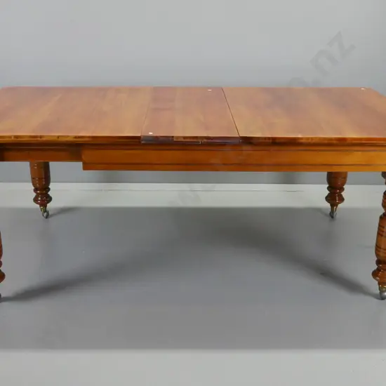 Victorian rimu wind-out extending dining table on heavy turned legs with brass caps and replacement Shepherd's casters -